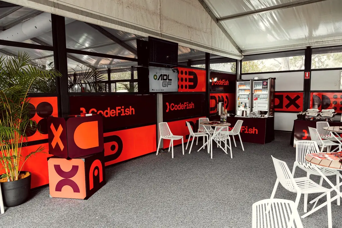 CodeFish branded hospitality marquee with white chairs and tables