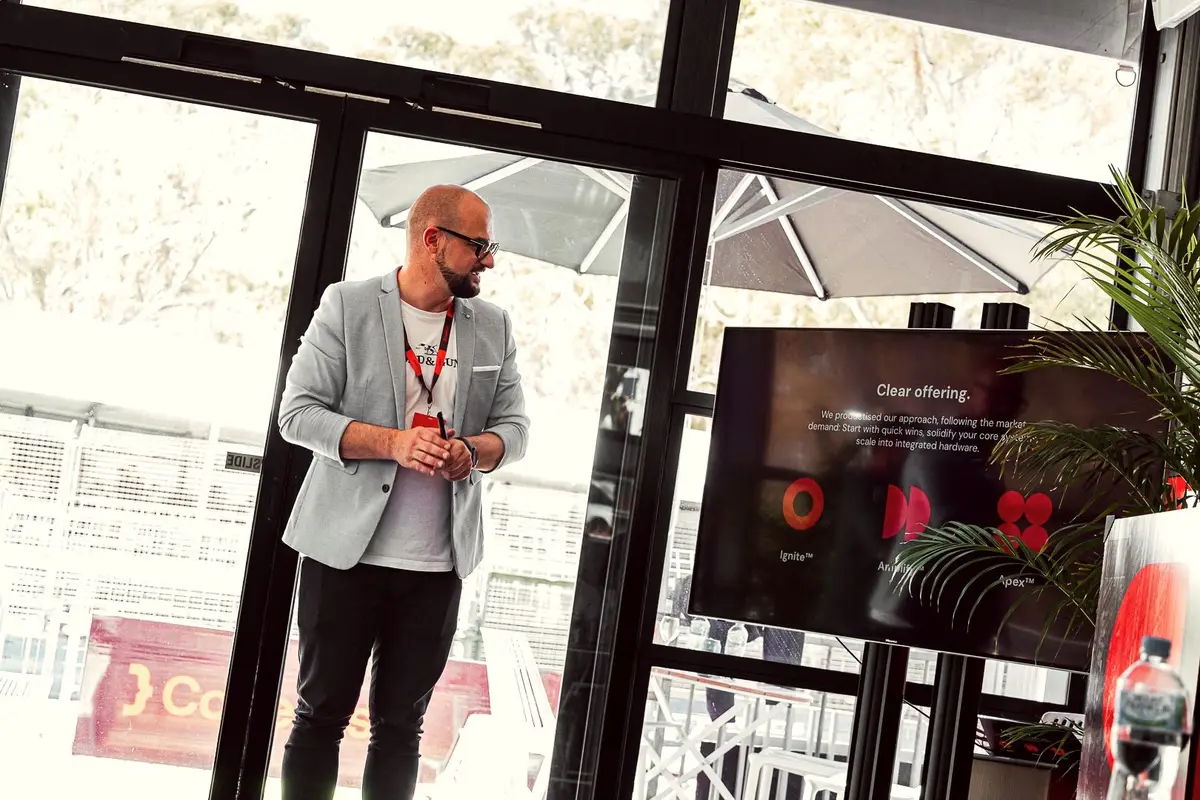 Presenter beside a screen showing the Ignite, Amplify and Apex offering