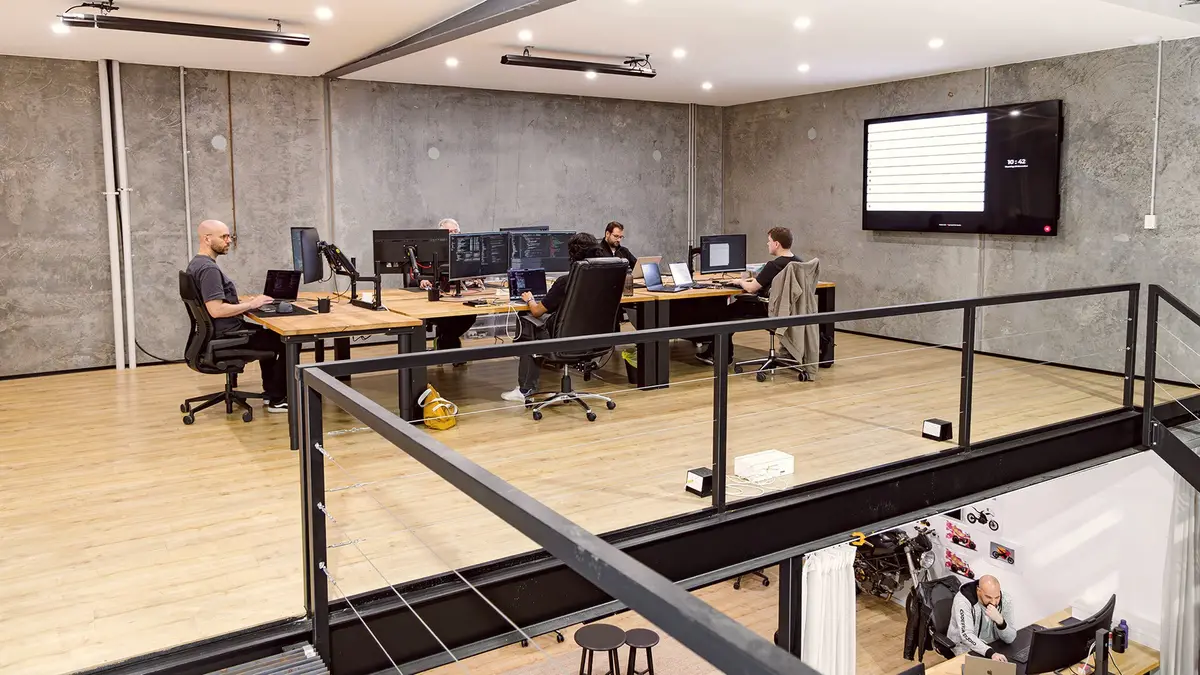 CodeFish mezzanine office with developers at desks and a large wall display
