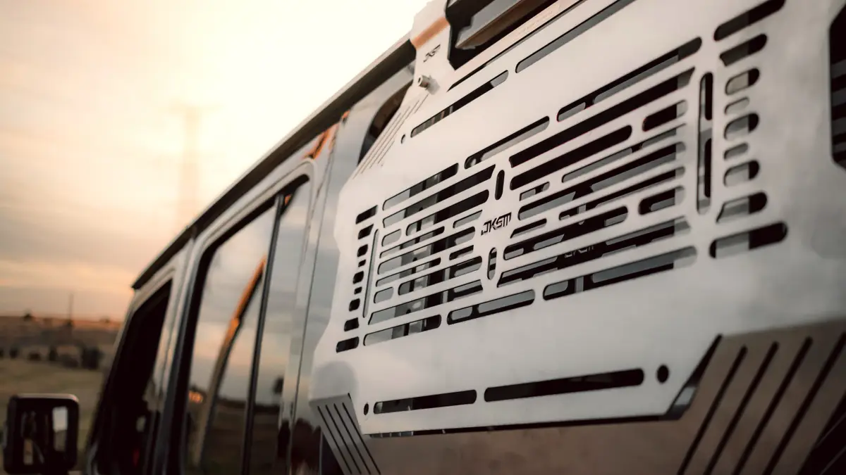 Close-up of a JKSM stainless steel side panel on a vehicle at sunset