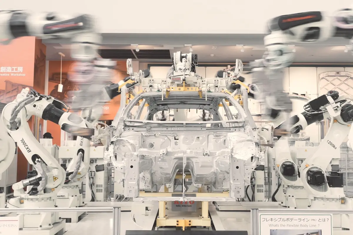 Robotic arms assembling a bare car body shell on an automotive flexible body line