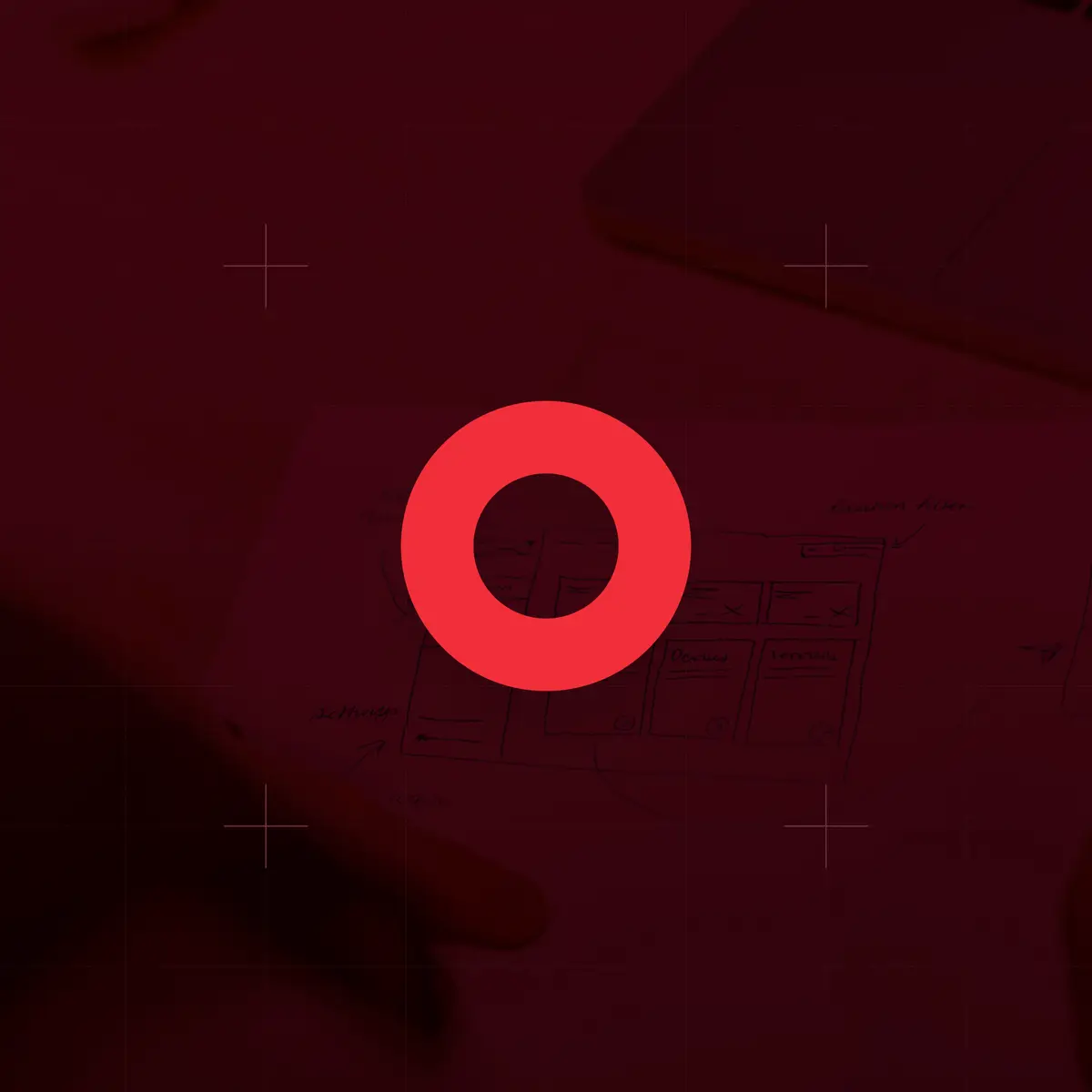 Red ring icon over a dark red photo of hands sketching wireframes
