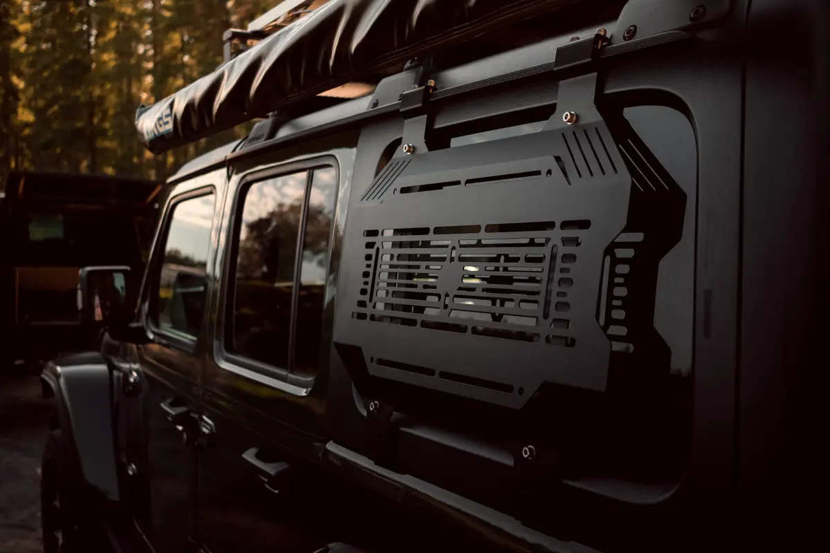 Side view of a black 4WD with a mounted rear window storage panel at dusk