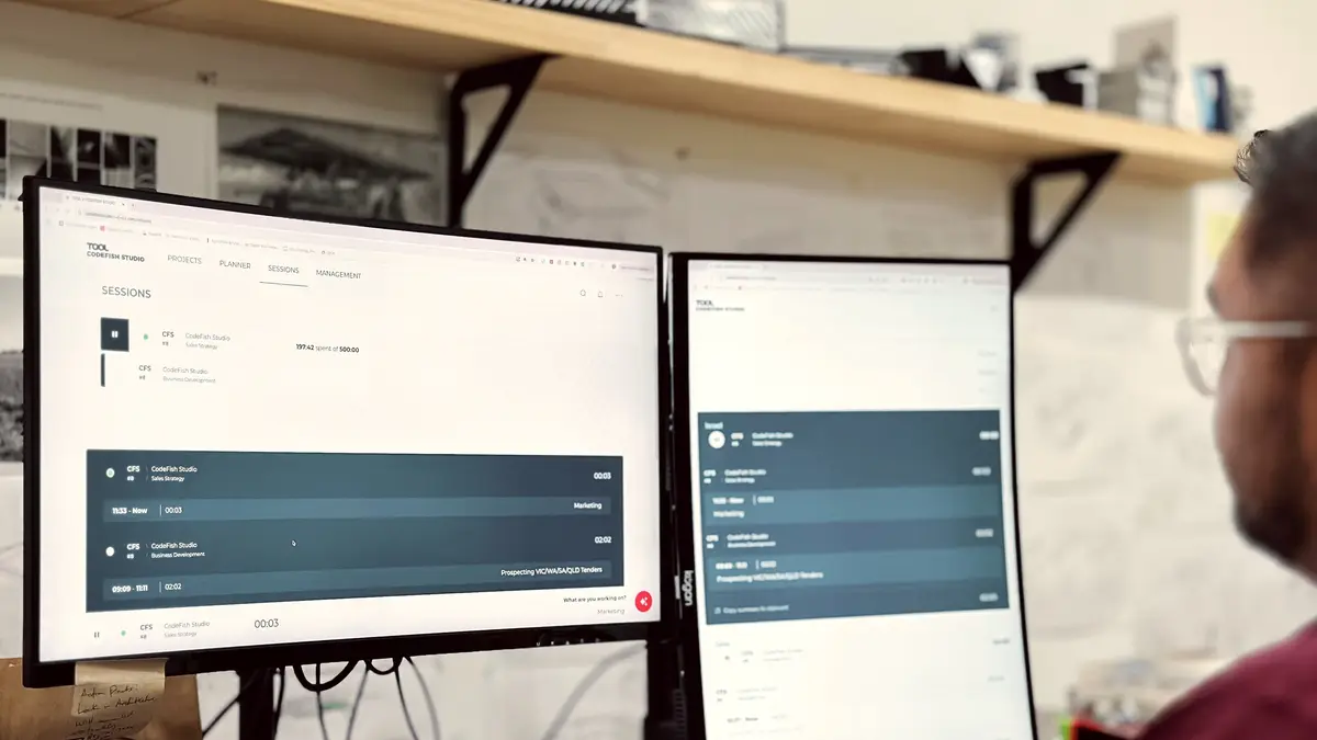 Person viewing the TOOL sessions dashboard on two desktop monitors